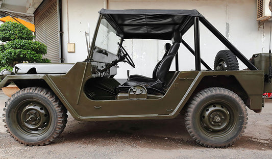 A military jeep with open doors and top down, showcasing a UTV with safety features and a rollover protection system.