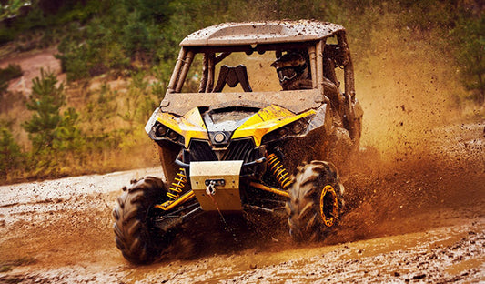 Yellow and black ATV driving through mud, towing your UTV, flatbed trailer, enclosed trailer.