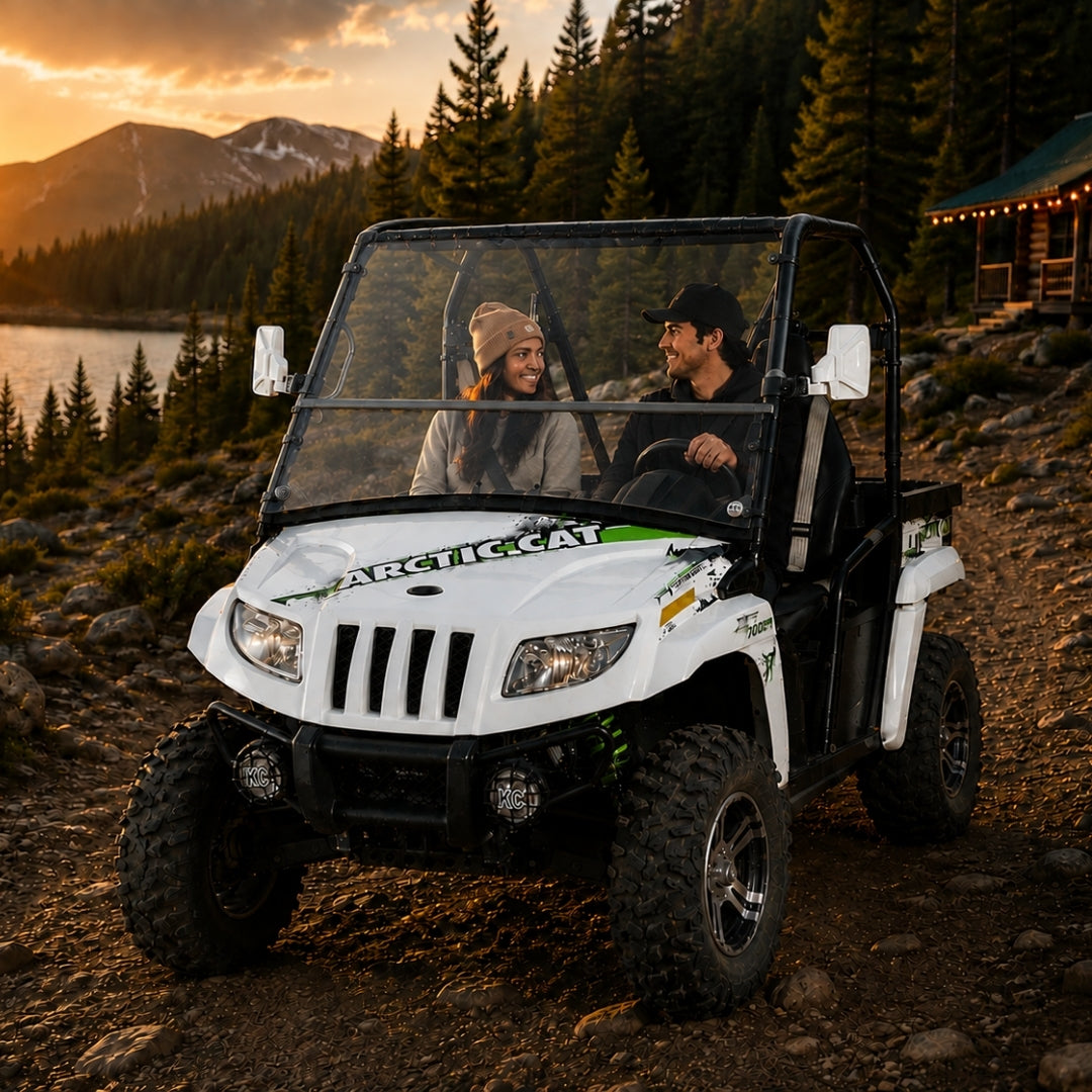 Two riders in a 2011-2014 Arctic Cat Prowler with a TerraRider tilting windshield, parked on a mountain trail