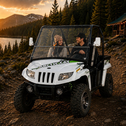 Two riders in a 2011-2014 Arctic Cat Prowler with a TerraRider tilting windshield, parked on a mountain trail