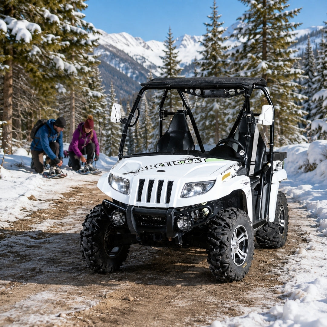 White Arctic Cat Prowler with full windshield on a snowy mountain trail with skiers