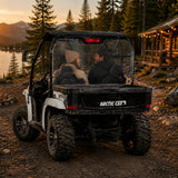 Two riders in a 2011-2014 Arctic Cat Prowler with a TerraRider rear windshield, parked on a trail at sunset