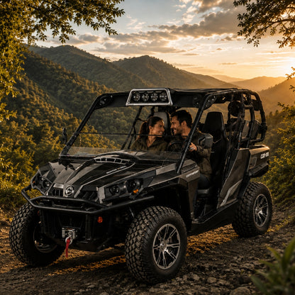 Two riders in a camo Can-Am Commander soft top with tilting windshield on a ridge trail overlooking a valley. gallery-2