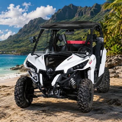 White Can-Am Maverick with full windshield on a beach with mountains behind