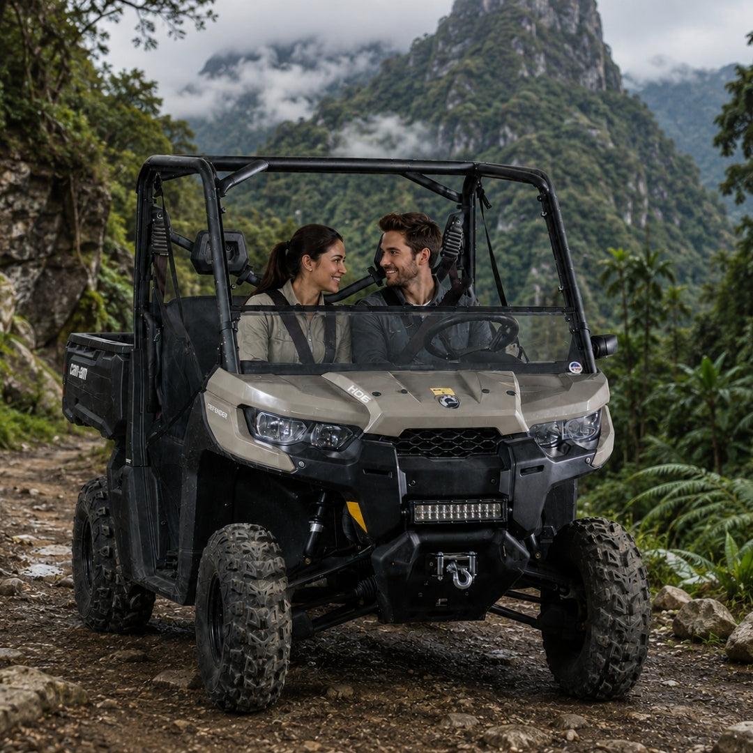 Two riders in a tan Can-Am Defender with tilting windshield on a mountain trail
