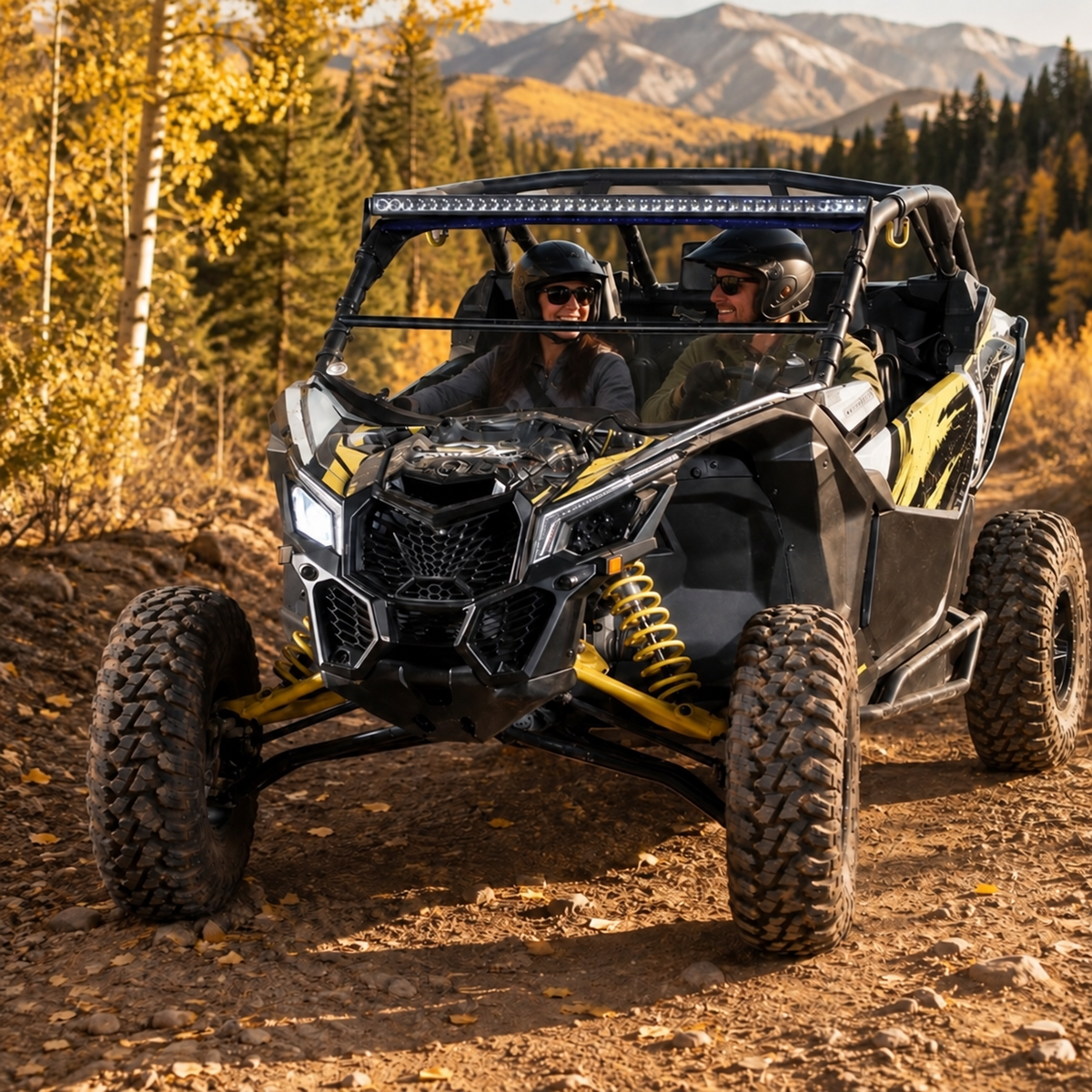 Black and yellow Maverick X3 with tilting windshield on a desert ridge at dusk, rider standing alongside. gallery-2
