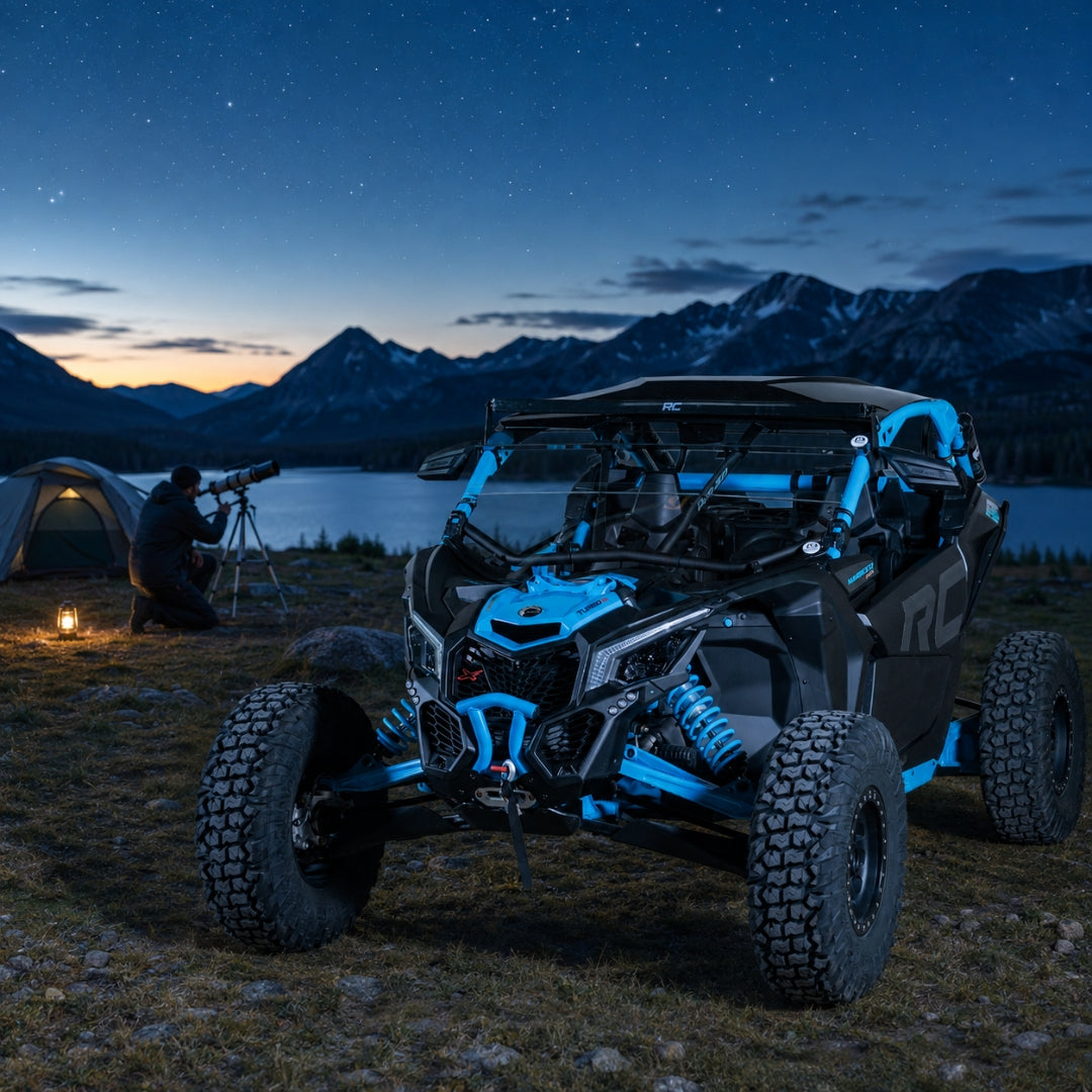 Blue Maverick X3 with half windshield parked by a lake at dusk beneath a deep blue sky. gallery-2