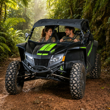Two riders in a black Arctic Cat Wildcat XX with full windshield on a jungle trail