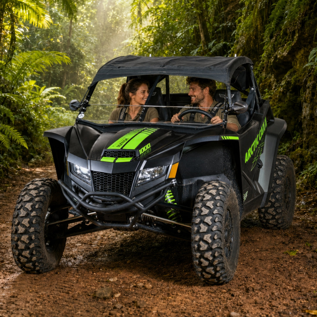Two riders in a black Arctic Cat Wildcat XX with half windshield on a jungle trail