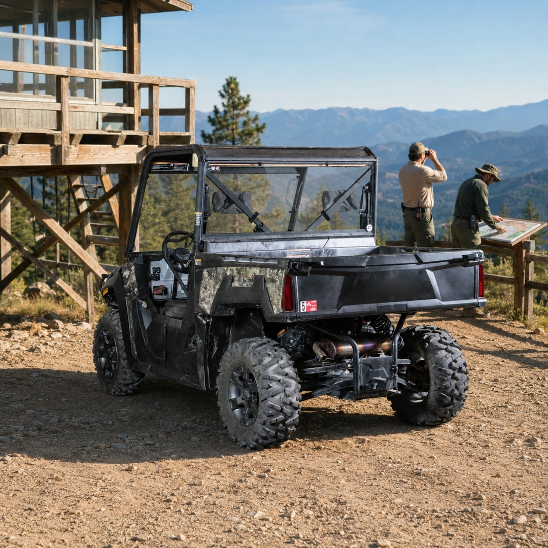 Camo Arctic Cat Prowler Pro with back windshield parked by a cabin deck with mountains behind