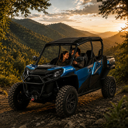 Blue Can-Am Commander with full windshield on a ridge trail at sunset with riders inside